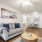 Modern living room with gray sofa, wood coffee table, and open floor plan leading to dining and kitchen area.