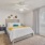 Primary bedroom with large window, ceiling fan, and cozy carpet flooring in Baton Rouge apartment home.