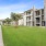 Open green courtyard with mature trees and walking paths between apartment buildings in Baton Rouge, Louisiana.
