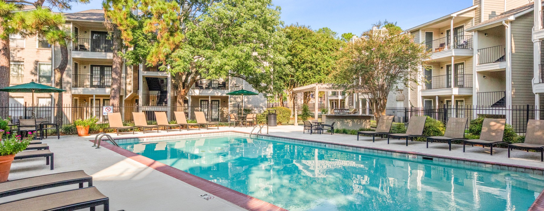 Outdoor Pool on Sundeck with lounge chairs within apartment community
