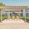 Outdoor pergola with lounge chairs beside the swimming pool at Sherwood Place Apartments in East Baton Rouge, Louisiana.